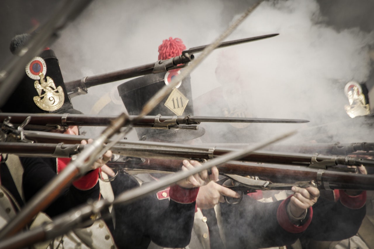 Soldiers of the French line infantry firing their weapons during a historical reenactment of the Napoleonic wars of the 19th century.