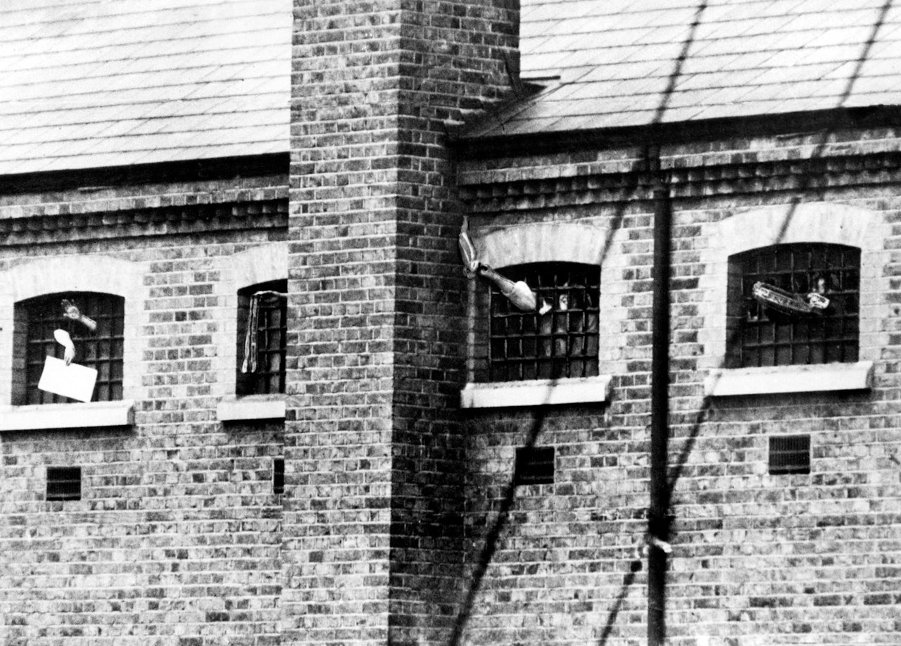 Suffragettes in their cells at Holloway Prison, waving through the bars. Circa 1909.