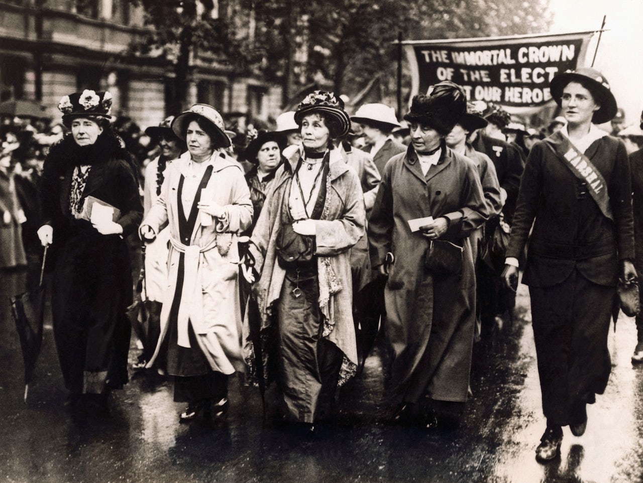 Emmeline Pankhurst leading a march through the rain.