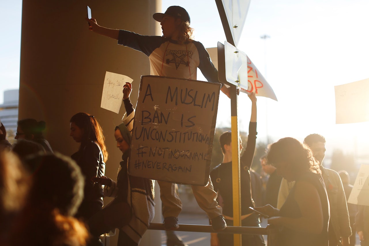 A demonstrator takes a photograph during a rally against Muslim immigration ban at San Francisco International Airport.