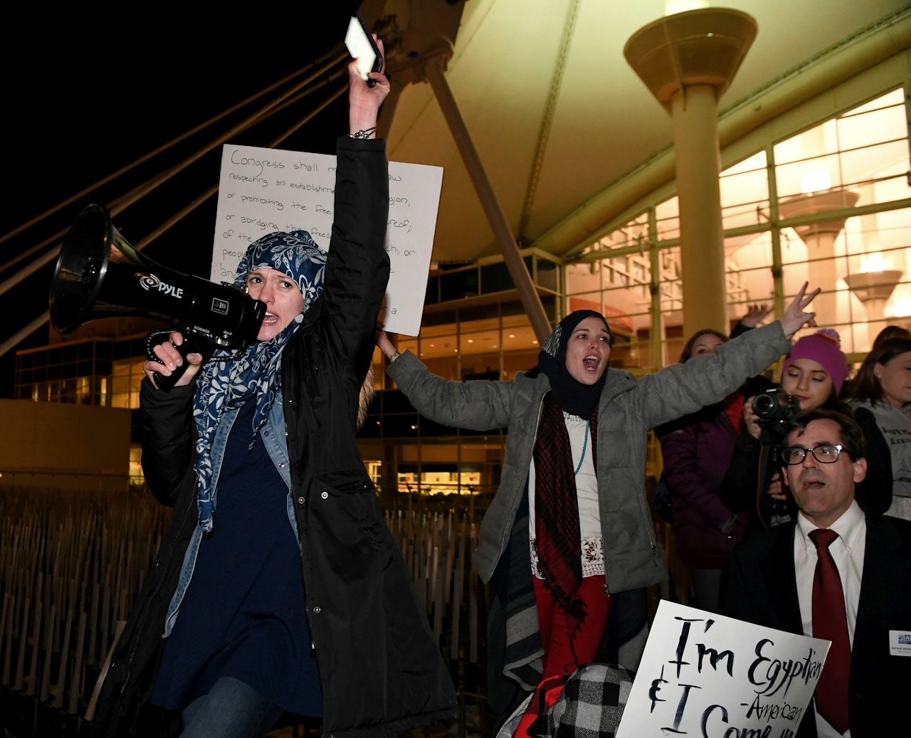 Amal Kassir, a Syrian American, leads the crowd during an immigration protest at Denver International Airport.