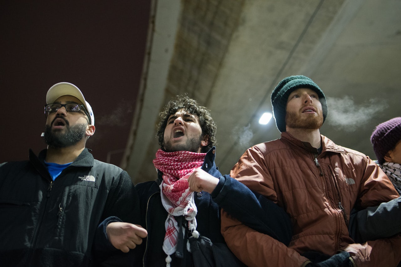 People link arms blocking traffic on the road outside Terminal 5 at O'Hare International Airport in Chicago.