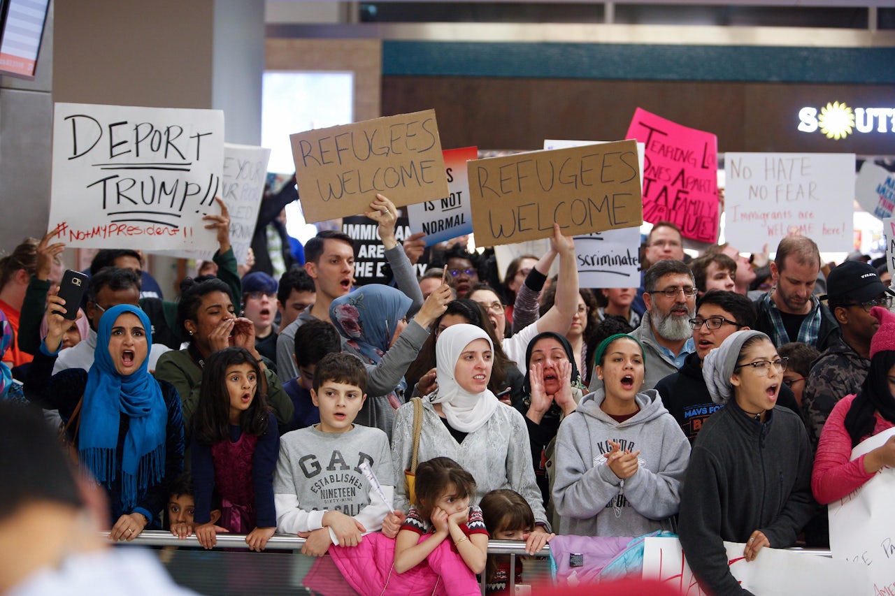 Protesters gather to denounce President Donald Trump's executive order that bans certain immigration, at Dallas-Fort Worth International Airport.