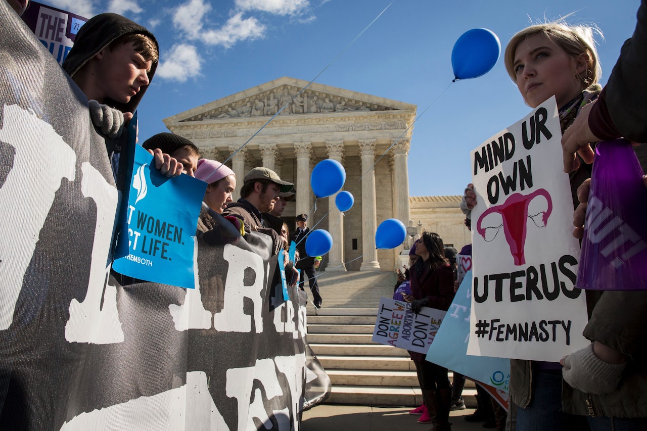Pro-choice advocates (right) and anti-abortion advocates (left) rally outside of the Supreme Court, March 2, 2016, in Washington, D.C.