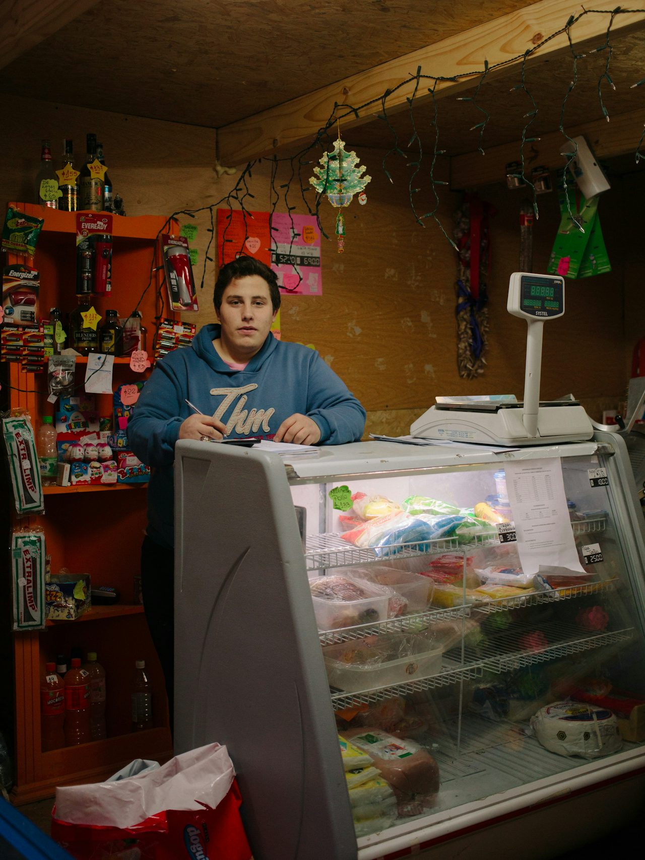 Augustine works as a clerk in one of the few shops inside the occupied Dos Banderas neighborhood, in the middle of the woods.