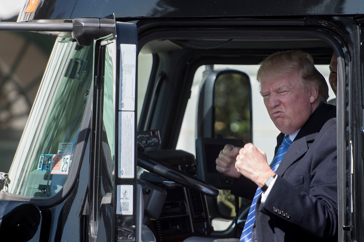 President Donald Trump sits in the driver’s seat of a Volvo semi-truck outside the White House.
