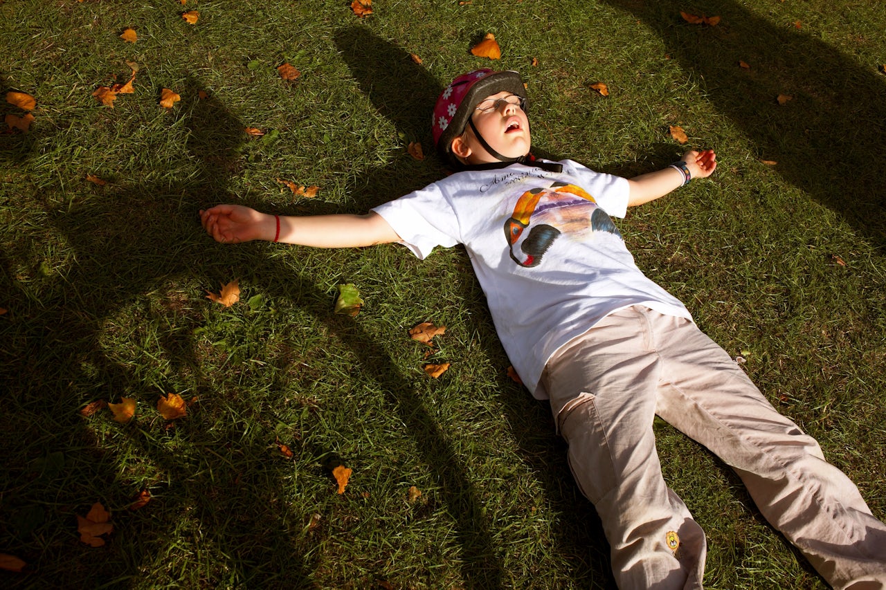 A young cyclist enjoys the grass grass at Peckham Rye Park in South London.