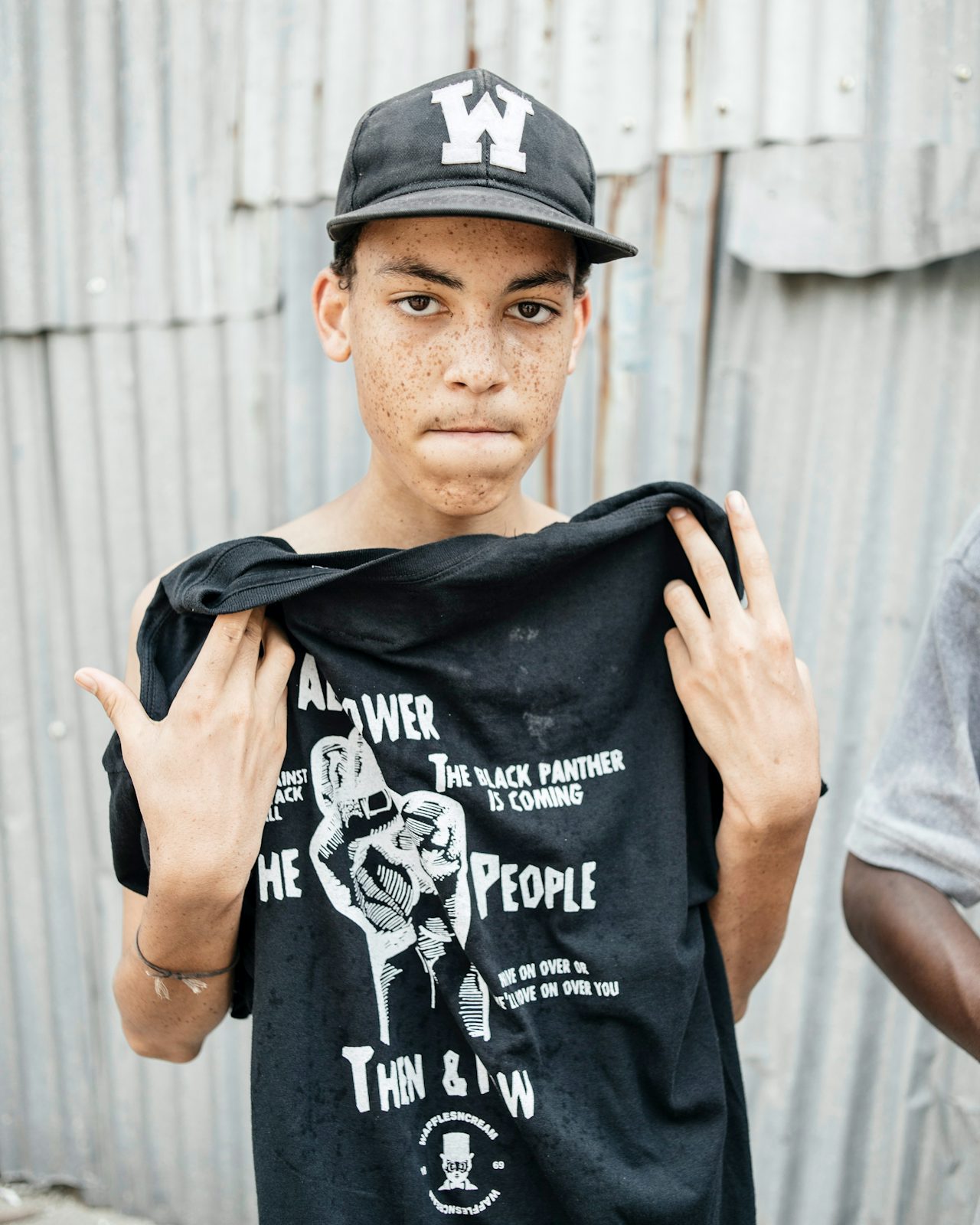 A skater holds up a Wafflesncream T-shirt inspired by the Black Panther Party.