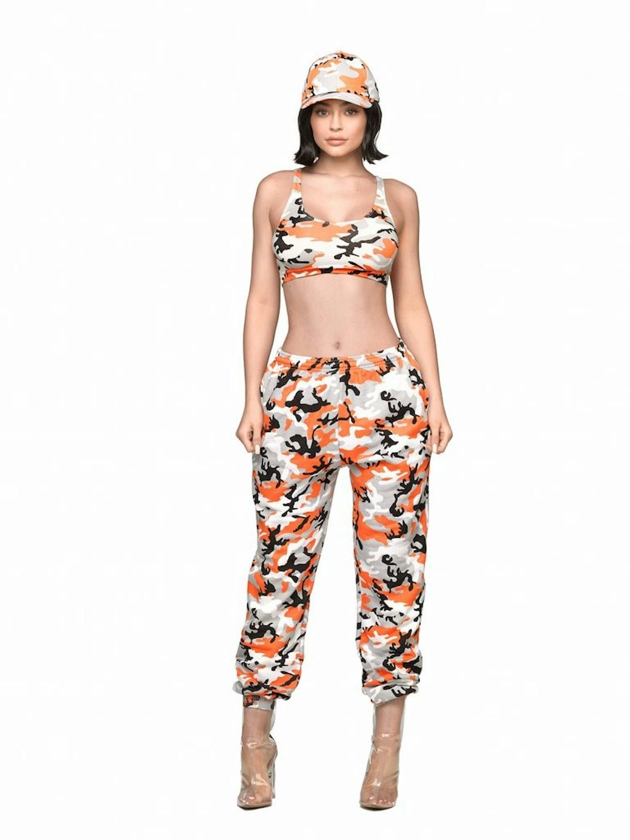 Kylie Jenner wears an orange camo top and sweatpants by Kylie Jenner Shop.
