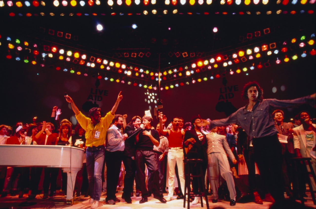Bob Geldof (right with arms outstretched) onstage with performers at Live Aid at Wembley Stadium in 1985.