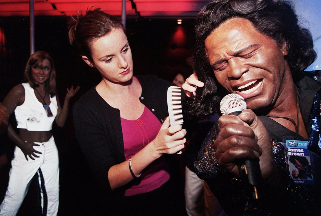 Hair stylist Anna Lane touches up a James Brown wax figure at Madame Tussauds London in 1999.