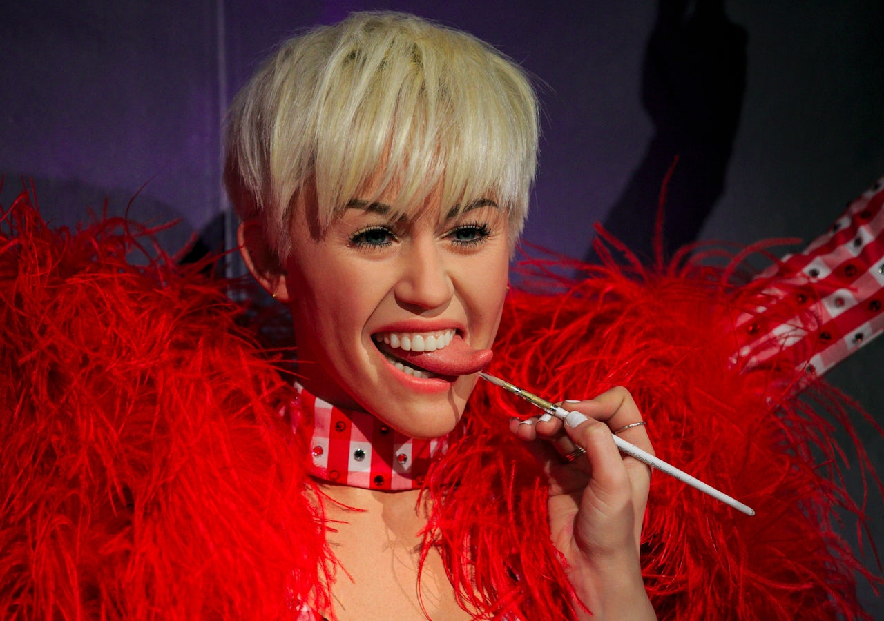 An artists paints a Miley Cyrus wax figure in Madame Tussauds London in 2015.