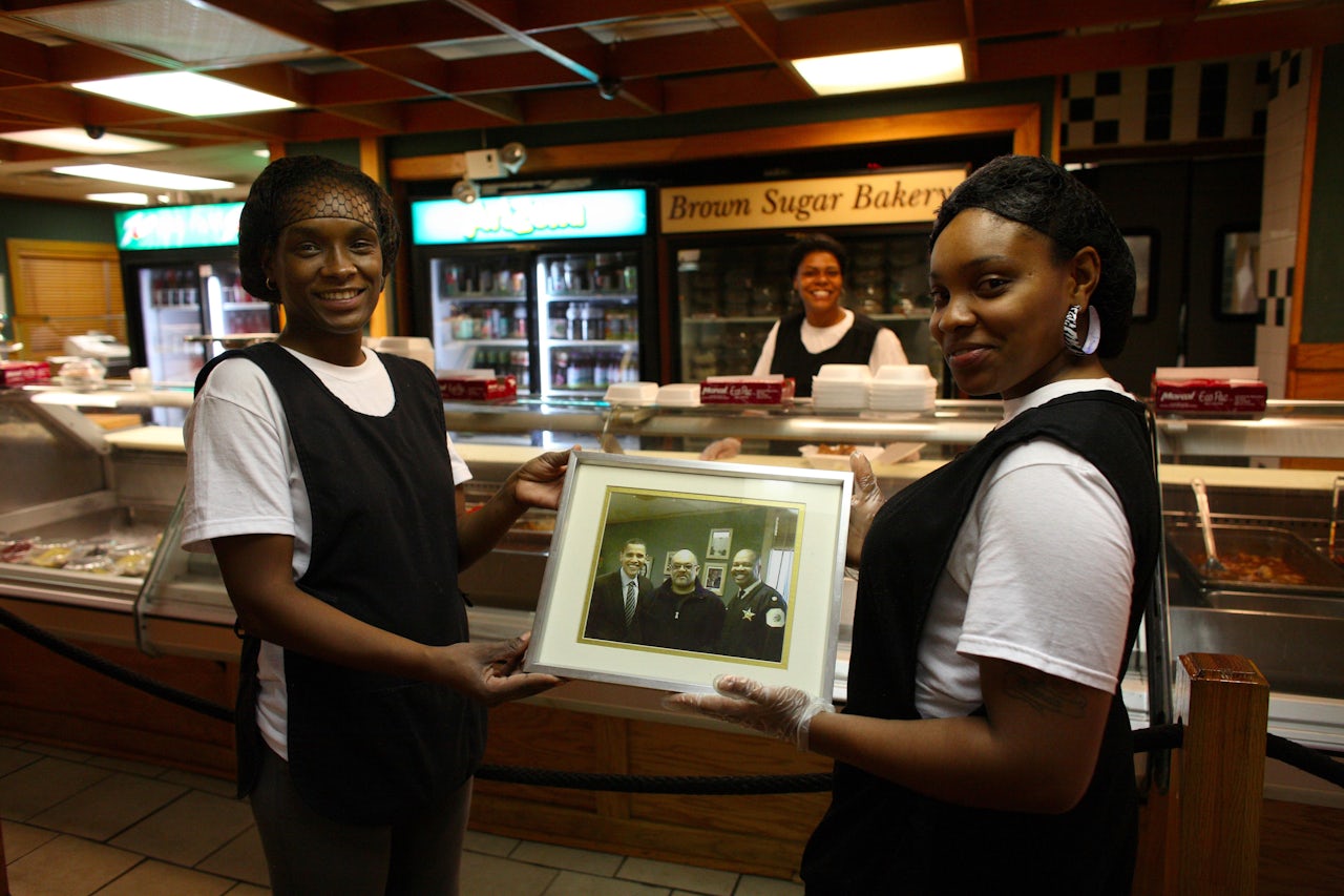 Servers at MacArthur's Restaurant in Chicago hold a photo featuring then-senator Barack Obama. Templeton credits Obama with drawing attention to black-owned restaurants.