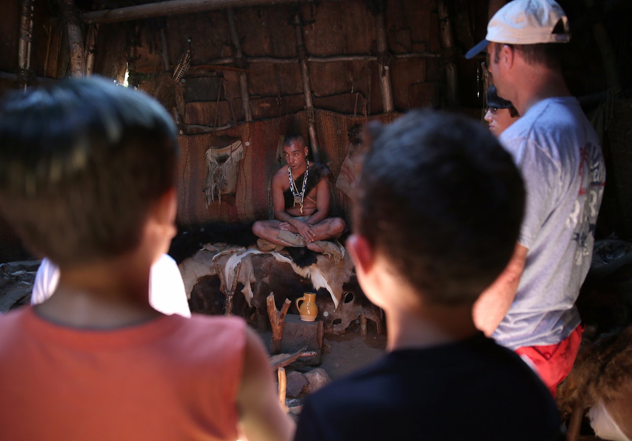 Visitors listen to an interpreter at the Wampanoag Homesite.