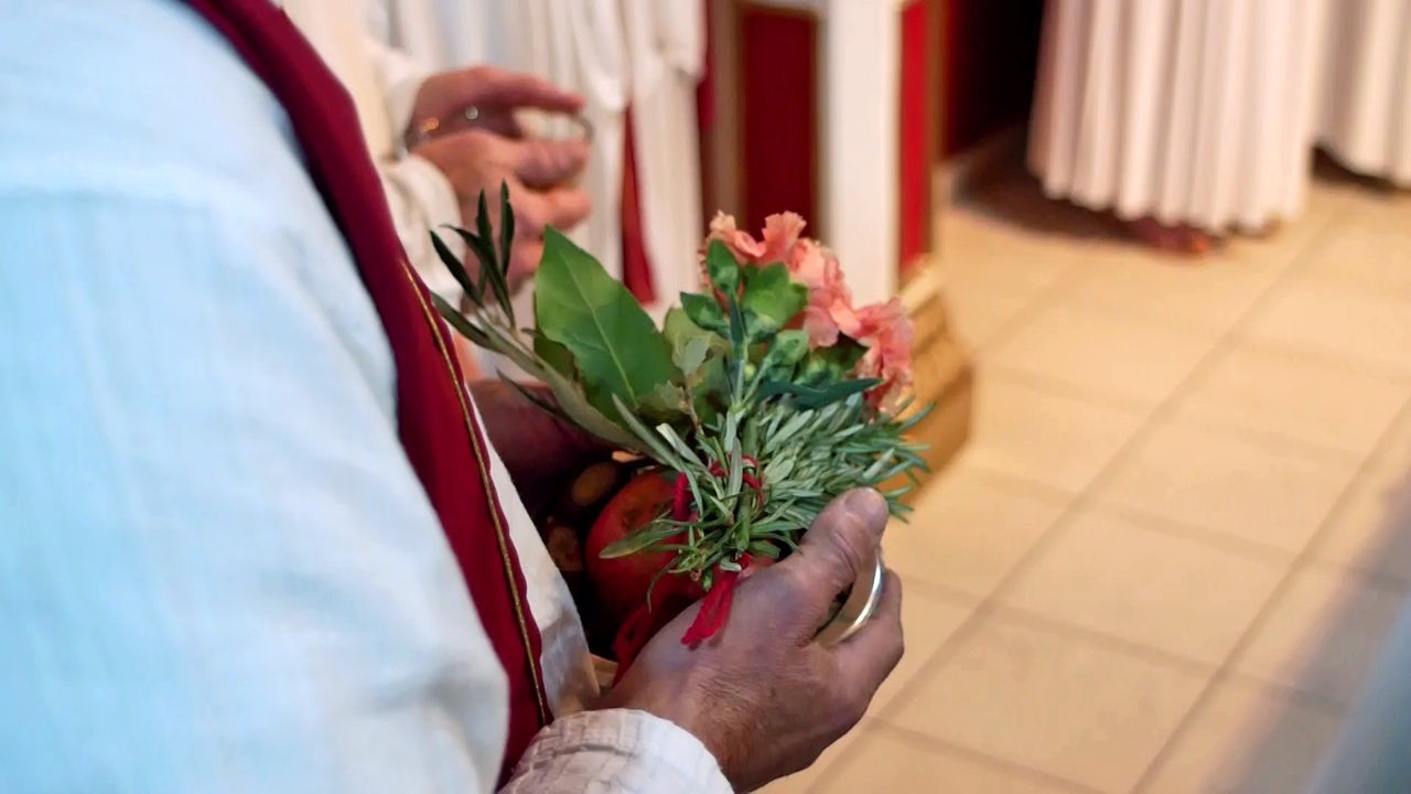 A priest holds flowers as offerings to the gods.