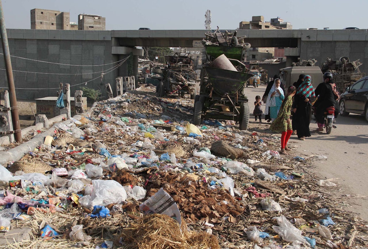 Excess trash spills over onto a roadway in Karachi.