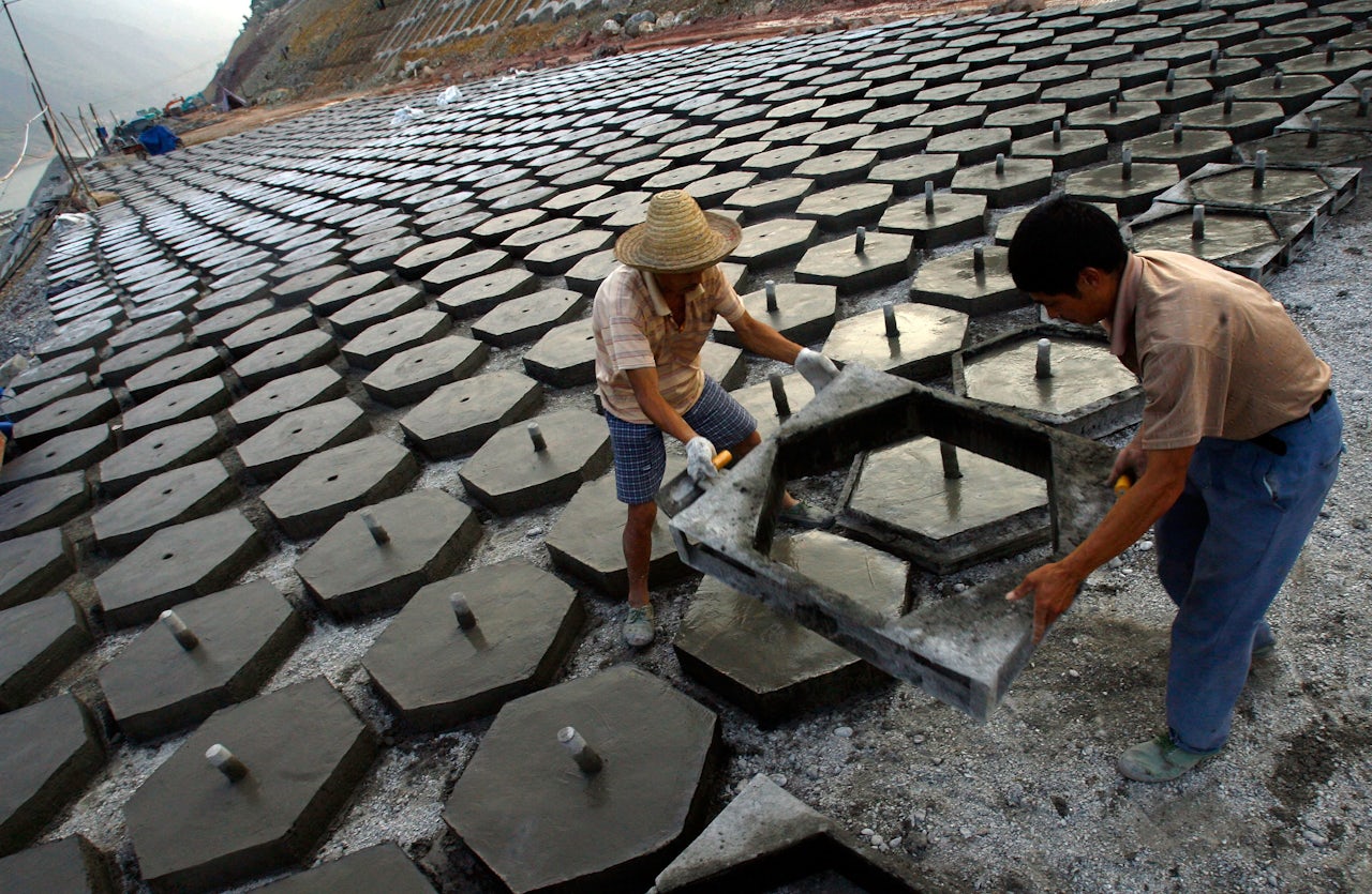 Workers pour concrete forms in an effort to harden the cofferdam of the Three Gorges Reservoir in China. Cement is the second-most consumed material in the world, after water.