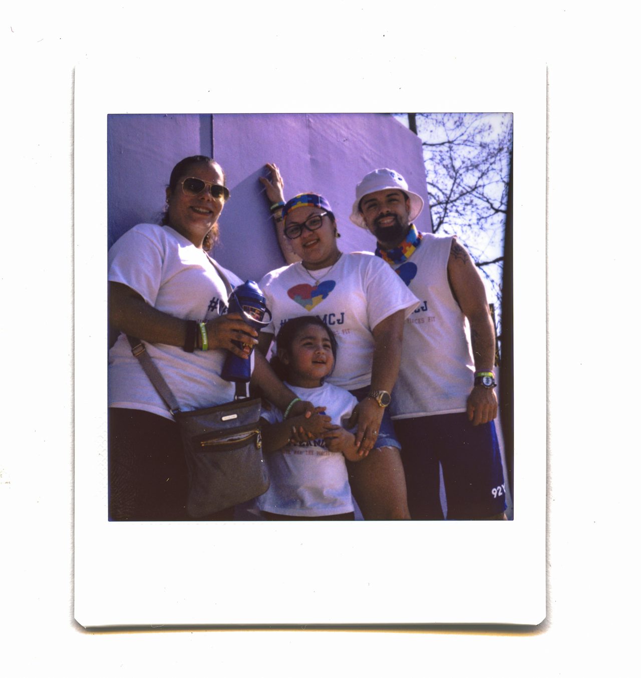 A family wearing matching t-shirts that read “#TeamCJ” pose for a photo together.