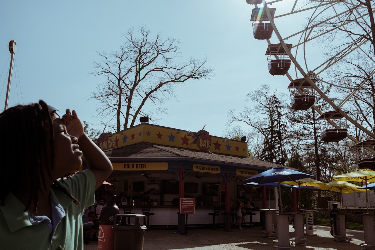 A young boy shields his eyes from the sun and gazes toward The Giant Wheel, the park’s 147-foot tall ferris wheel.