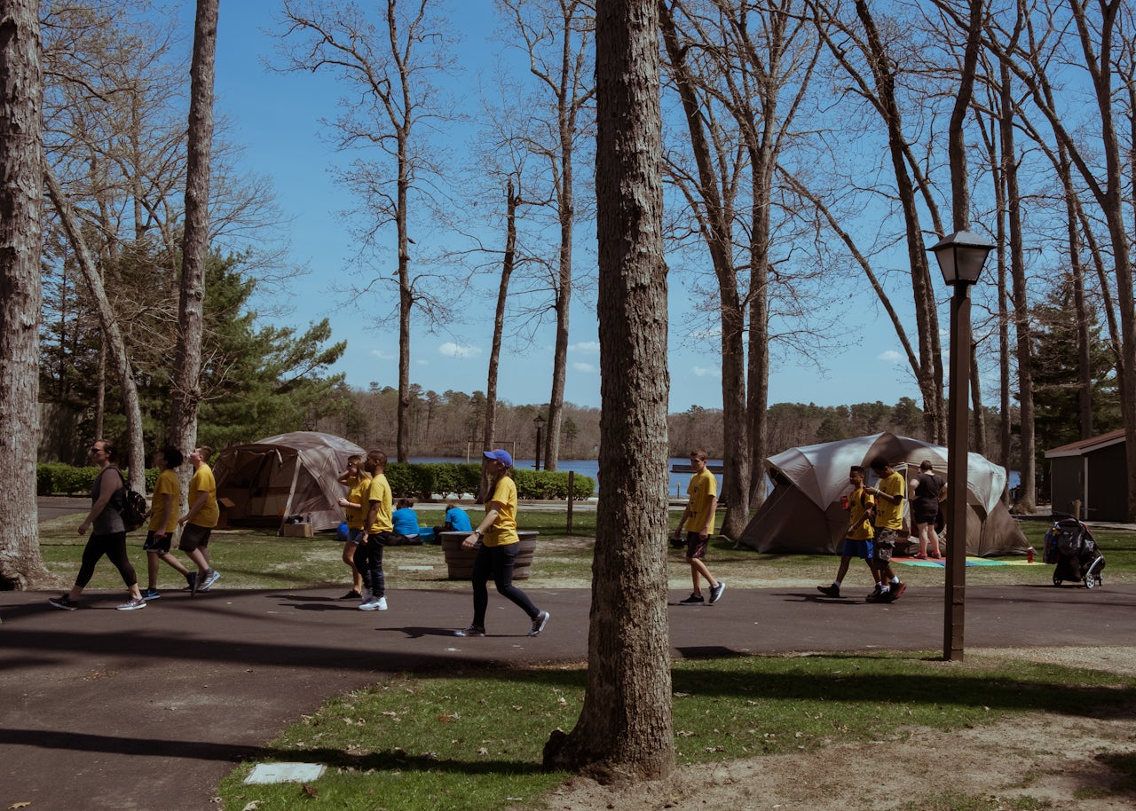 A group of children and accompanying adults walk past the Decompression Tents, located in the Six Flags Fantasy Forest.
