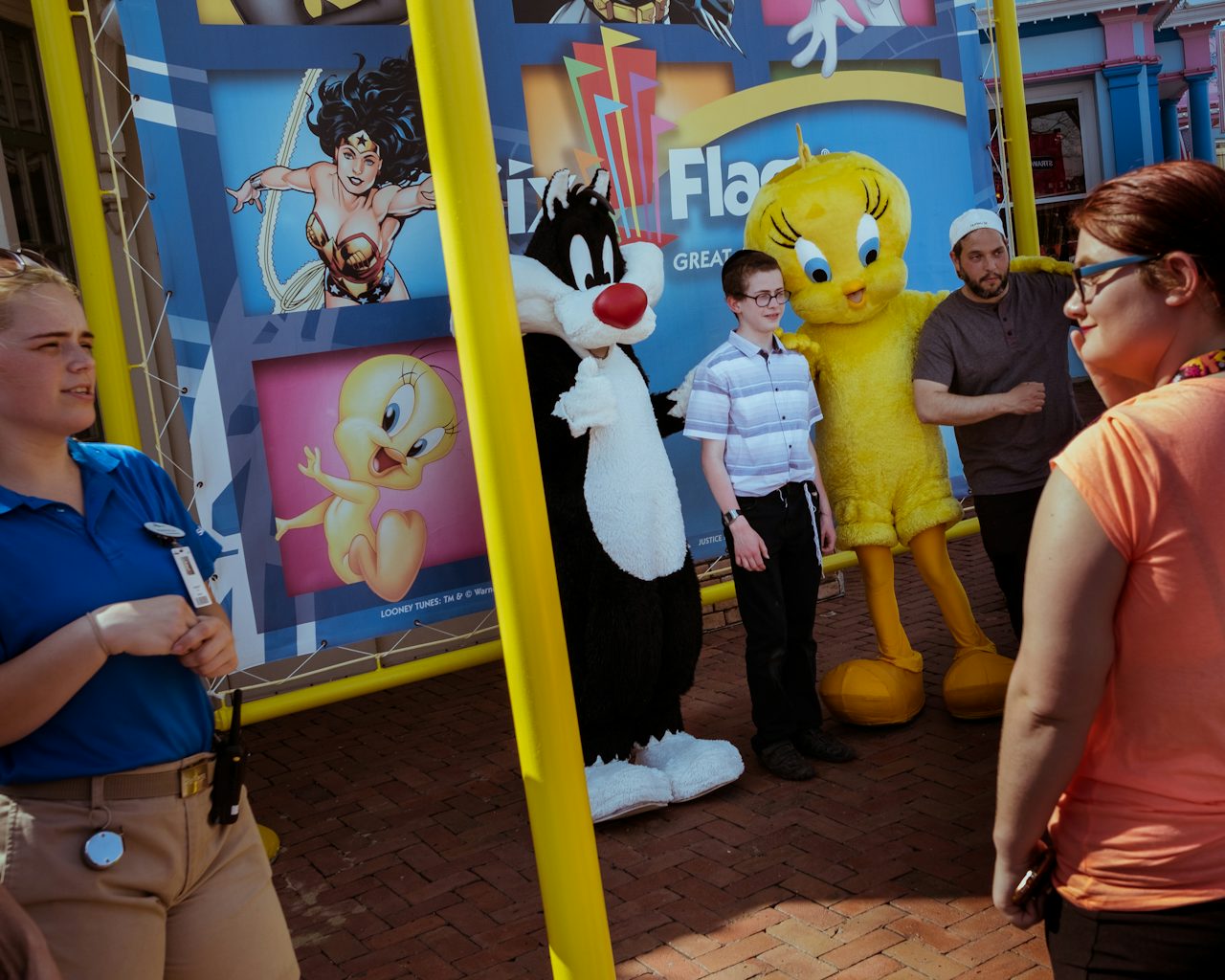 A boy and a young man pose for a photo together with Looney Tunes characters Sylvester the cat and Tweety Bird.