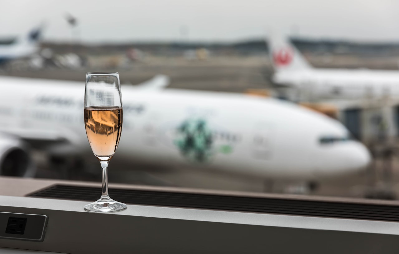 Шампанское в самолете можно. Бокал шампанского в аэропорту. Шампанское в аэропорту. Отпуск самолет. Шампанское в аэропорту фото.