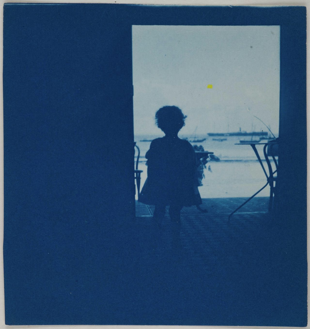 “Child standing in the doorway of a seashore house”