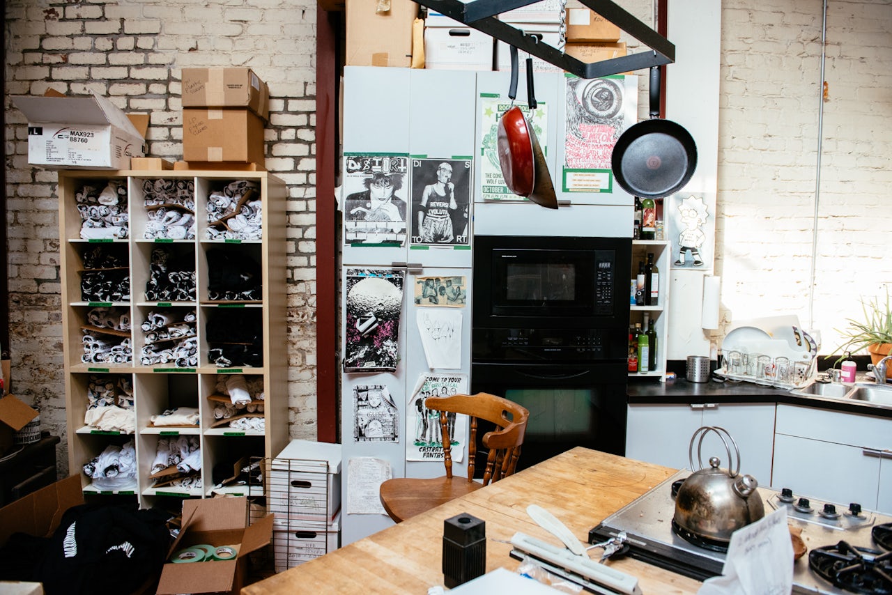 The green tape used to denote archived records is repurposed to hang posters and label drawers around the compound.
