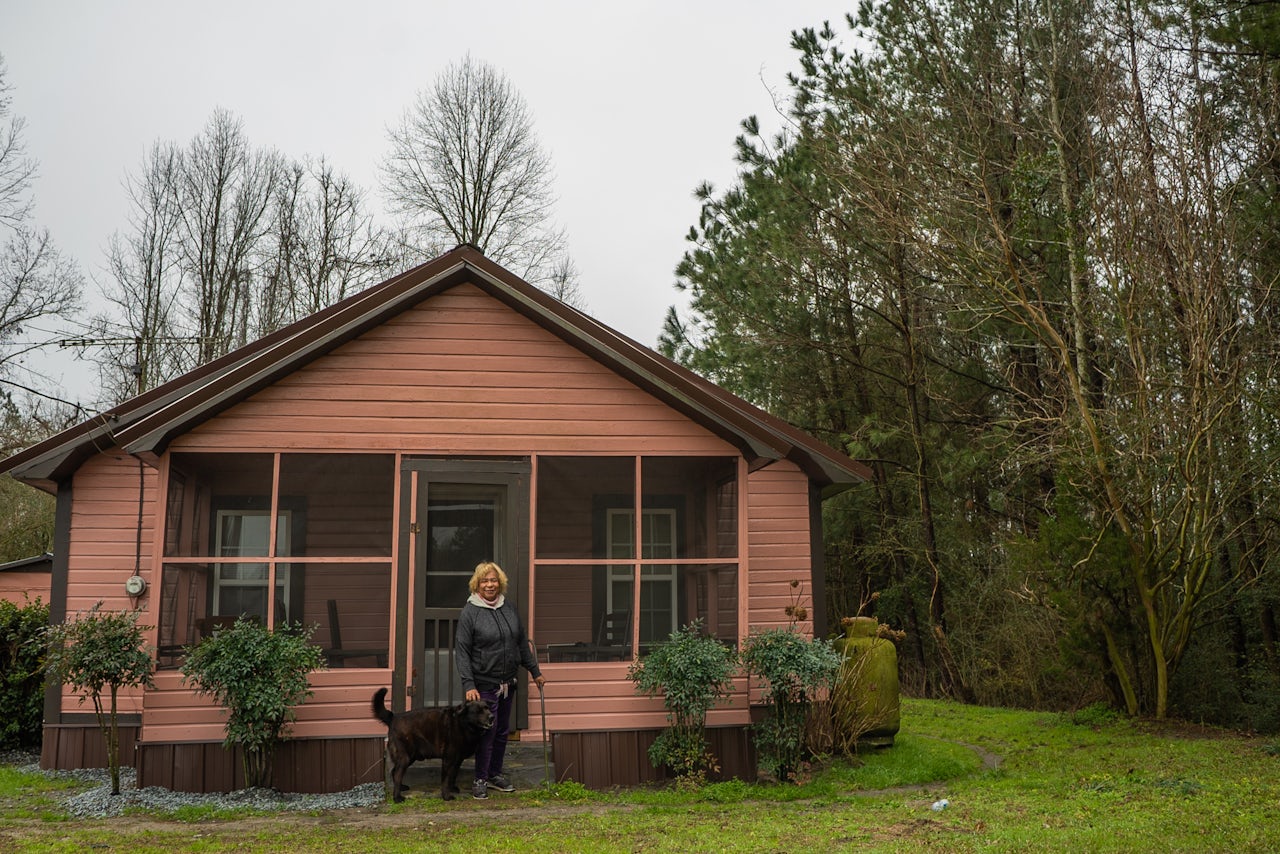 Elsie Herring and her dog Midnight in front of her home in Wallace, NC.